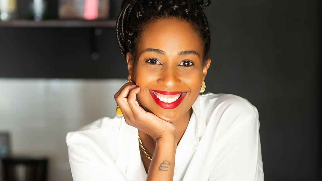 Retrato da confeiteira Carol Santos sorrindo com a mão no queixo, fundadora da Maravilhas da Carol